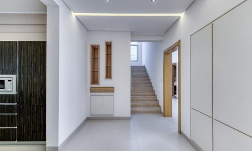 A hallway in a modern home with luxurious villa features and white cabinets.