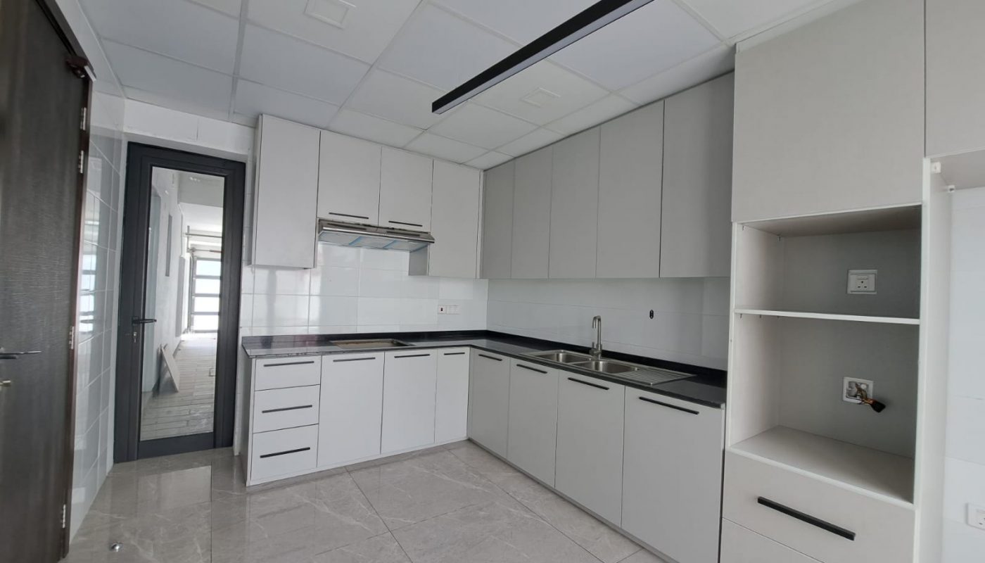 A white kitchen with stainless steel appliances and cabinets in a luxury villa.