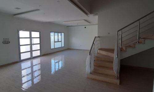 A large empty room with stairs leading up to it, available for sale in Bani Jamra.