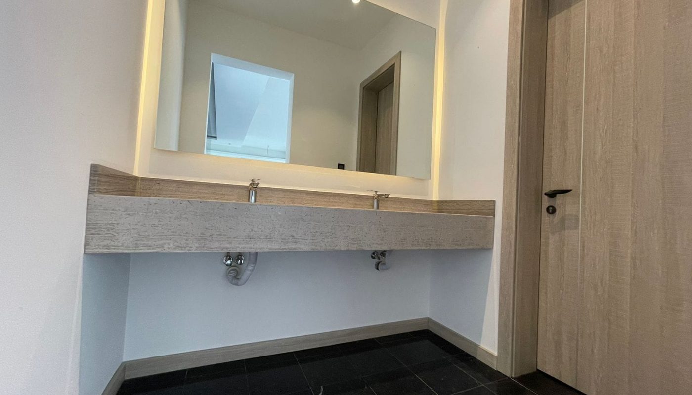 Luxury villa for sale with a bathroom featuring two sinks and a mirror.