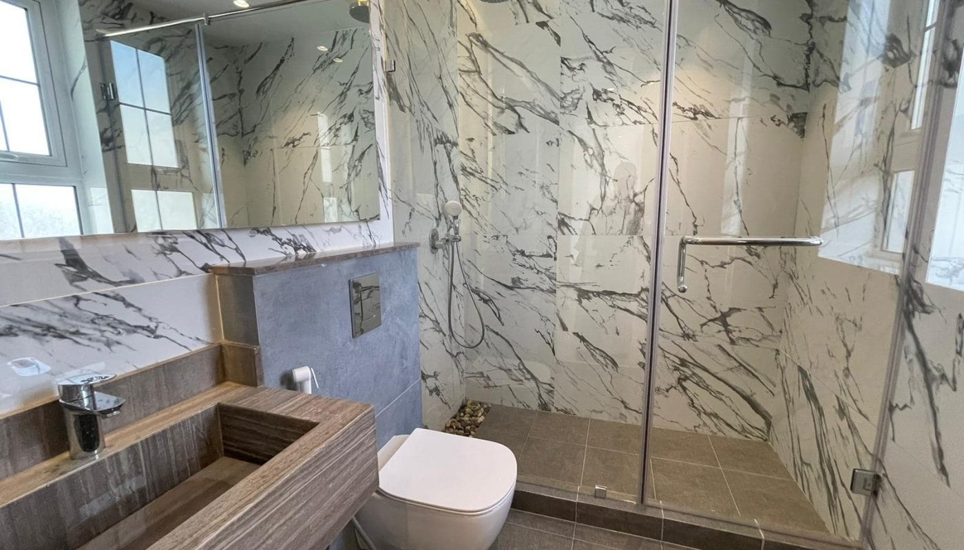 Zallaq Villa with marble walls and a glass shower stall available for sale.