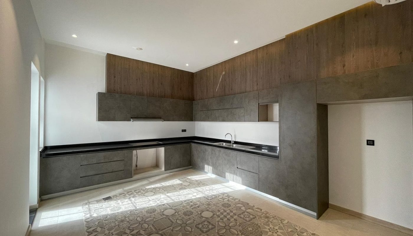 A luxury villa featuring a modern kitchen with wooden cabinets and a wooden floor.