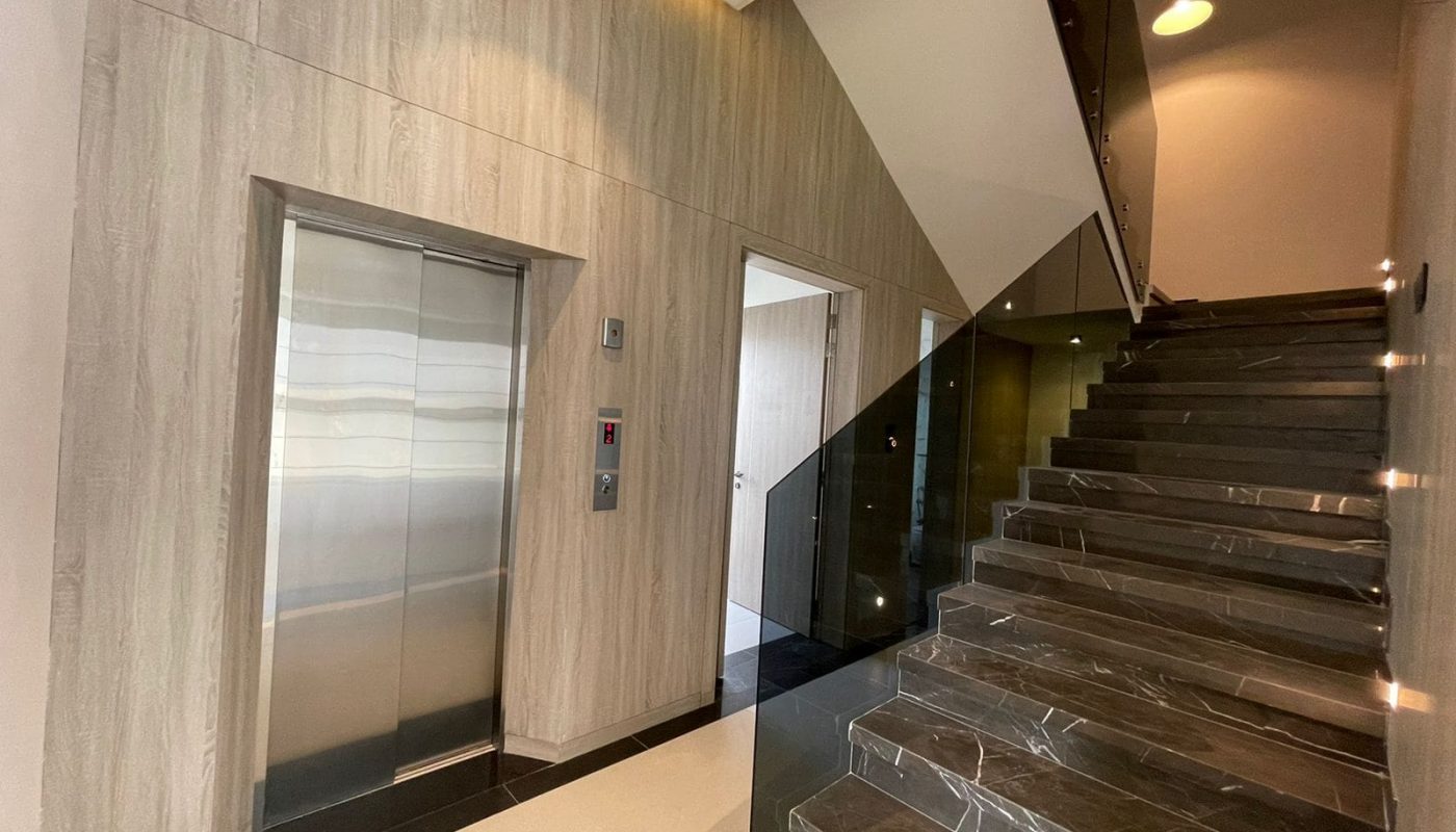 A luxury villa with a staircase leading to an elevator in a building.