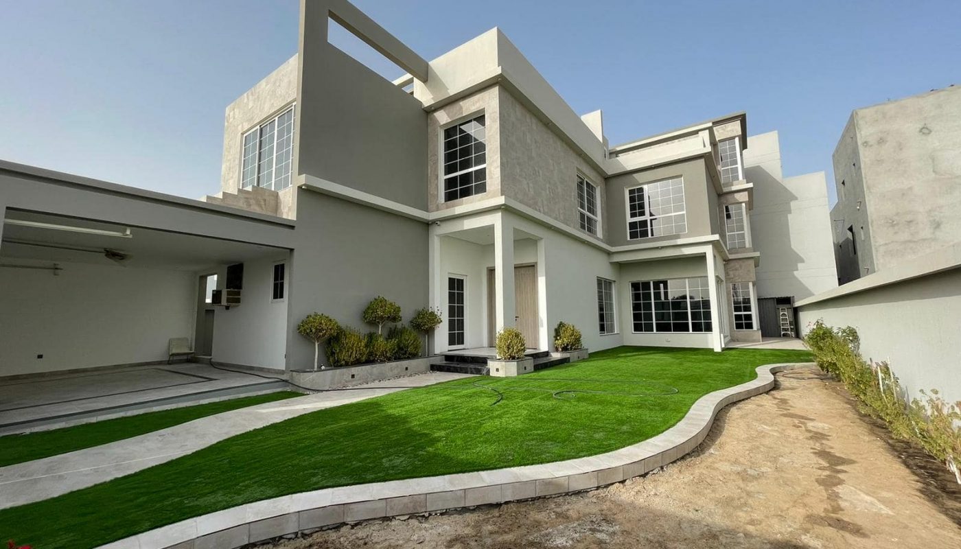 A luxury villa with grass in front of it.