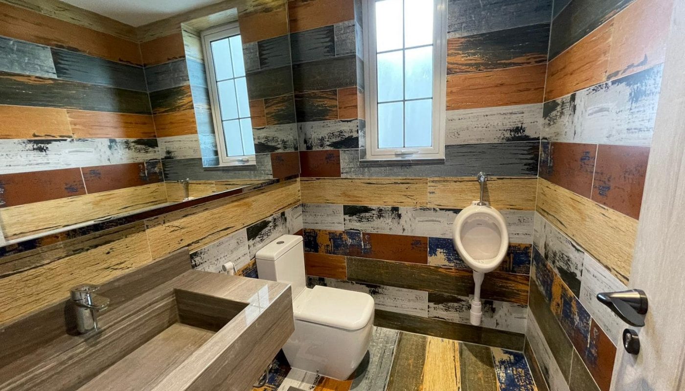 A luxurious villa with wooden walls and a bathroom featuring a toilet.