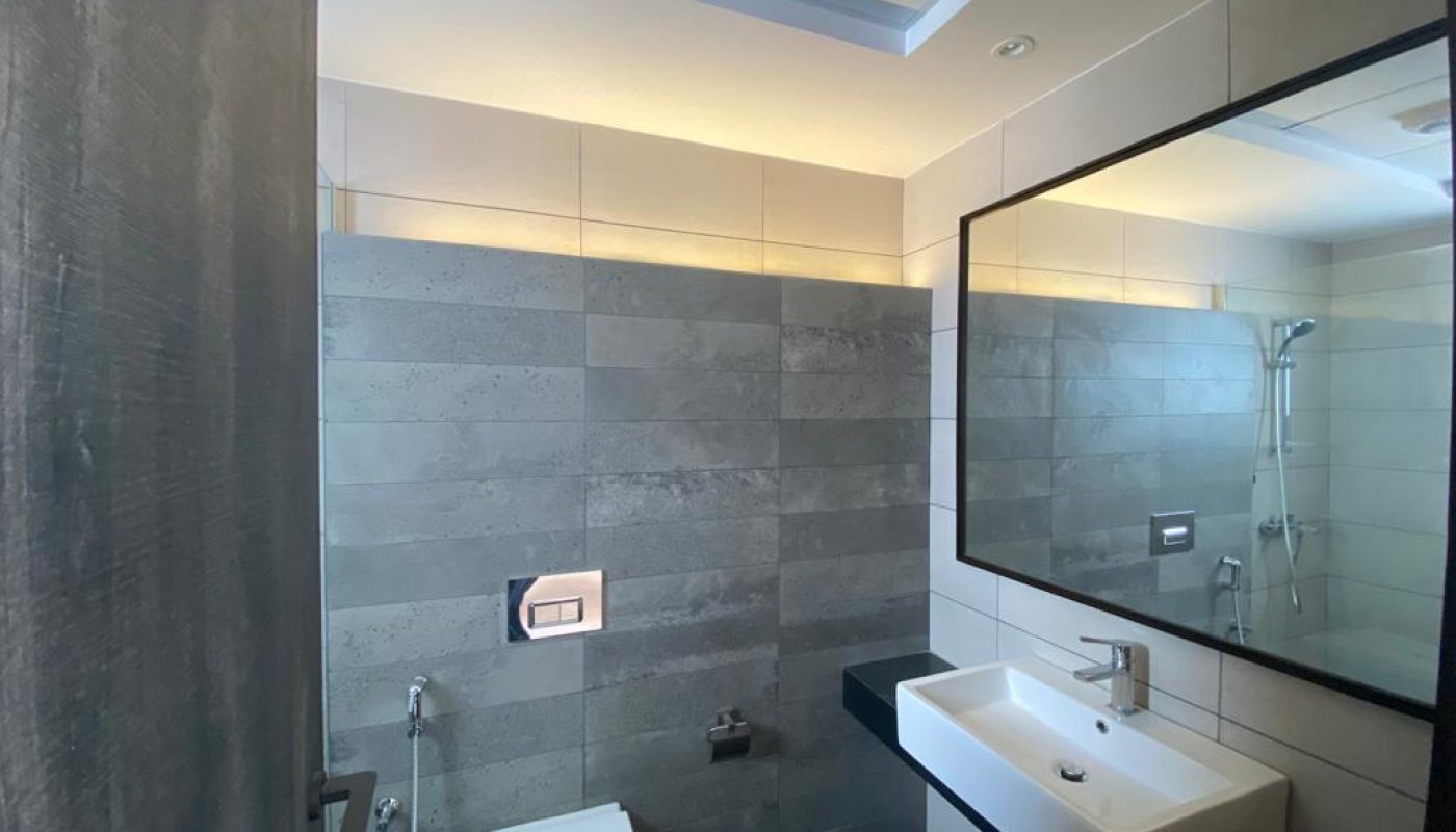 A brand new bathroom with modern amenities including a toilet, sink, and mirror.