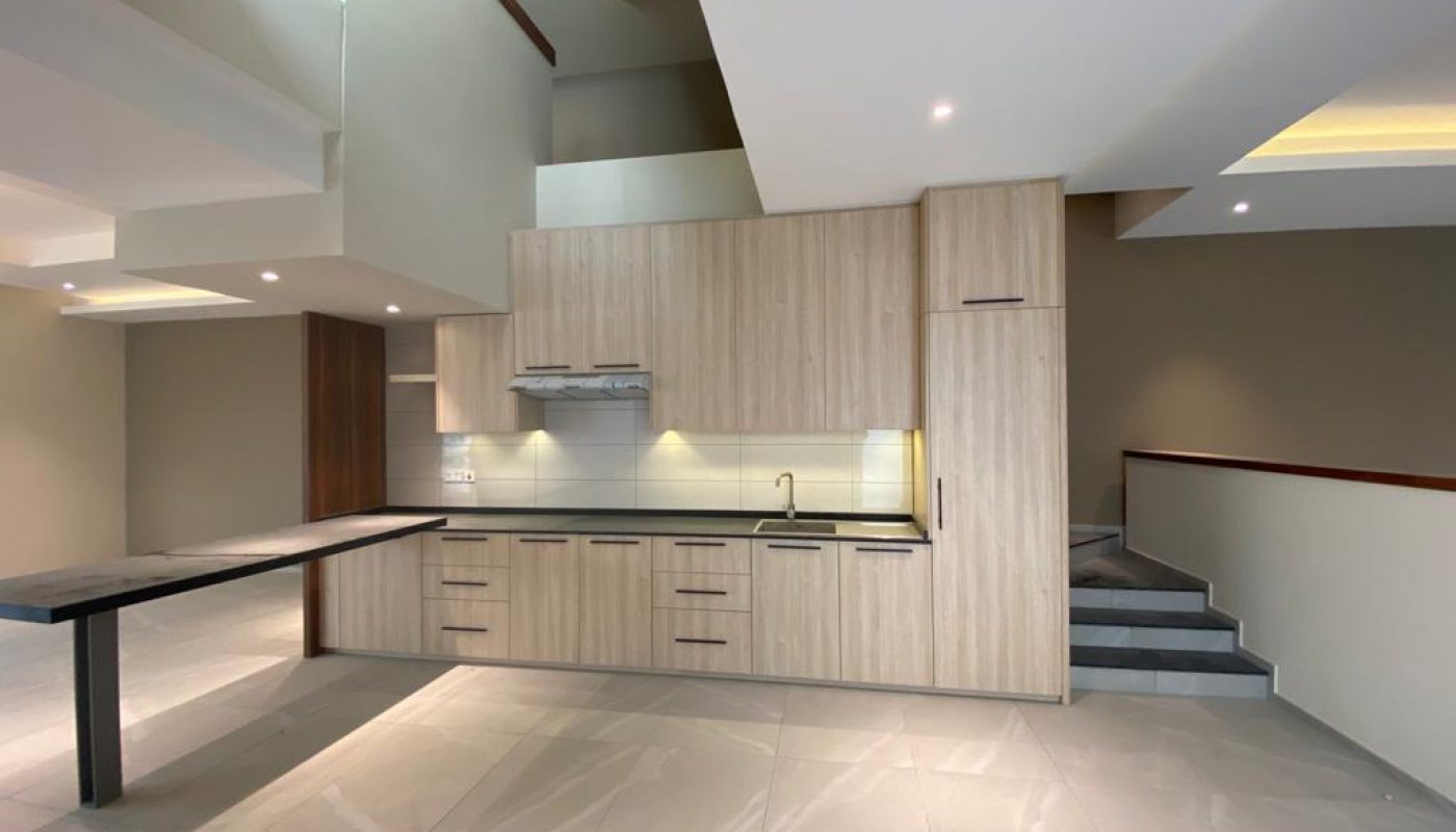 A modern kitchen with wooden cabinets and brand new counter tops.