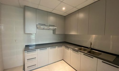 An empty kitchen with white cabinets and a sink in a BRAND NEW VILLA FOR RENT IN SAAR, featuring a modern design.