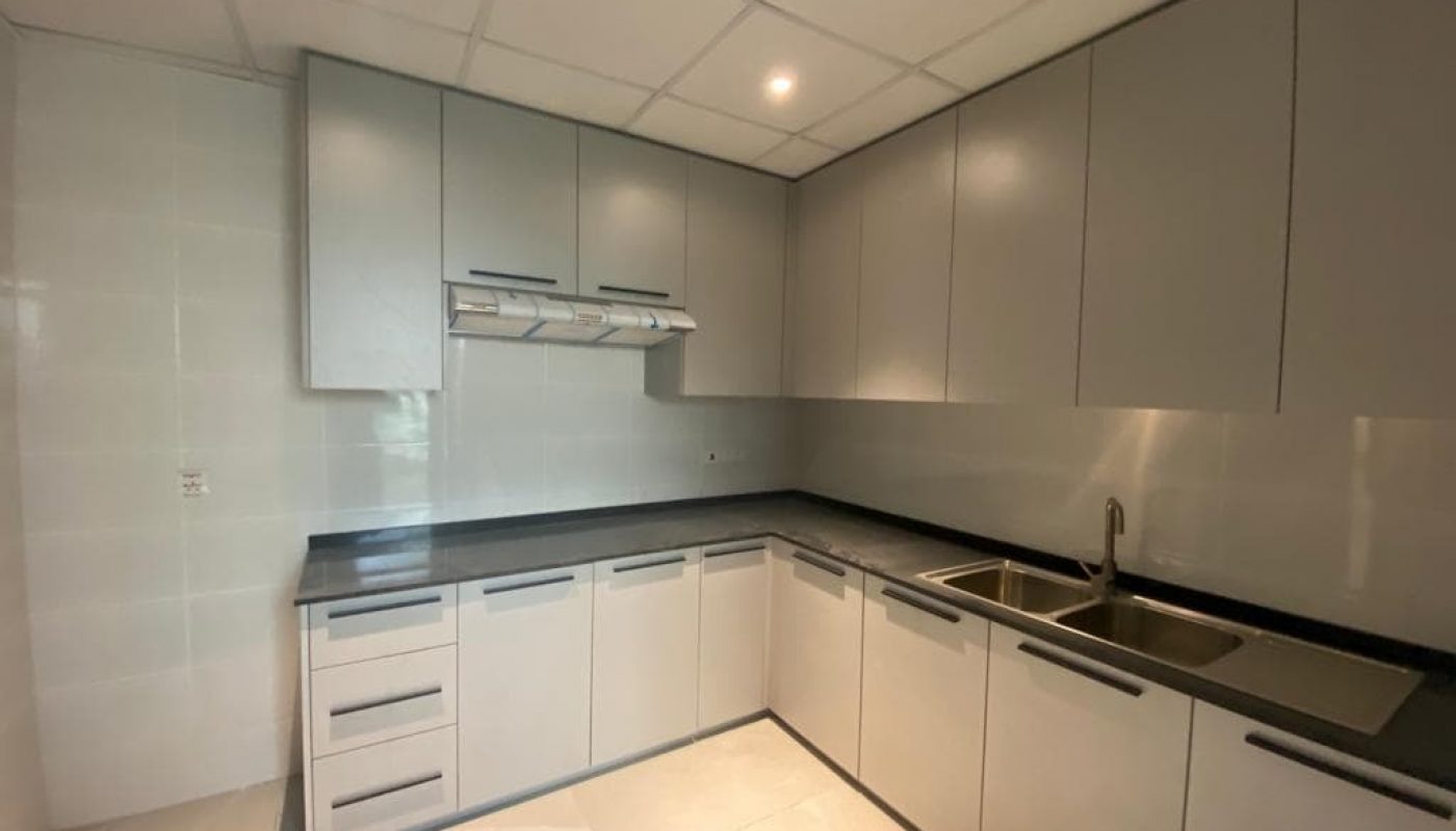 An empty kitchen with white cabinets and a sink in a BRAND NEW VILLA FOR RENT IN SAAR, featuring a modern design.