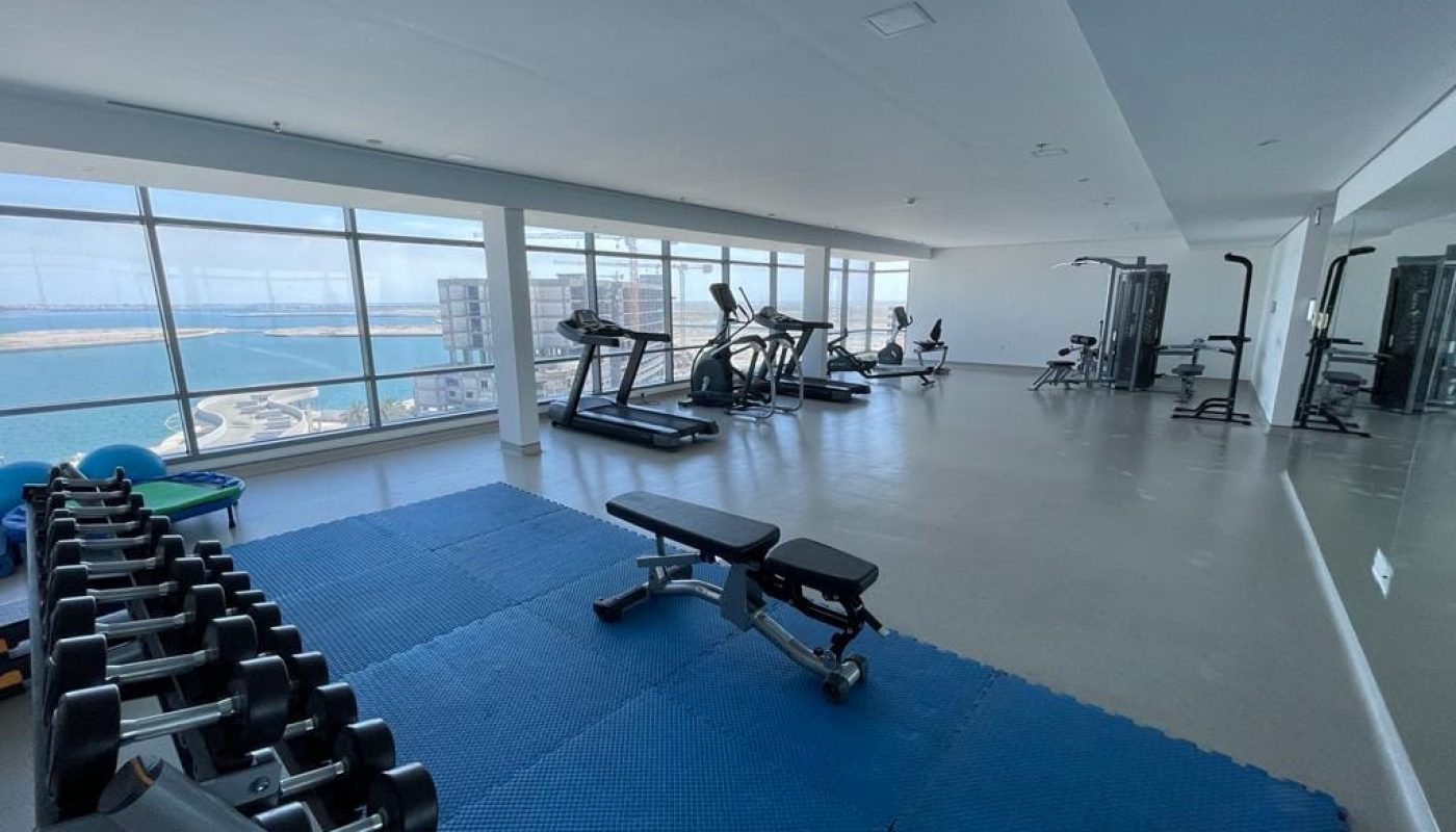 A gym room with a view of the Durrat Marina and ocean available for rent in the apartment.