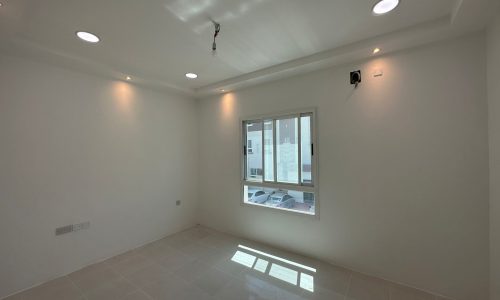 A commercial office for rent in Sanabis, featuring white tile floors and a window.