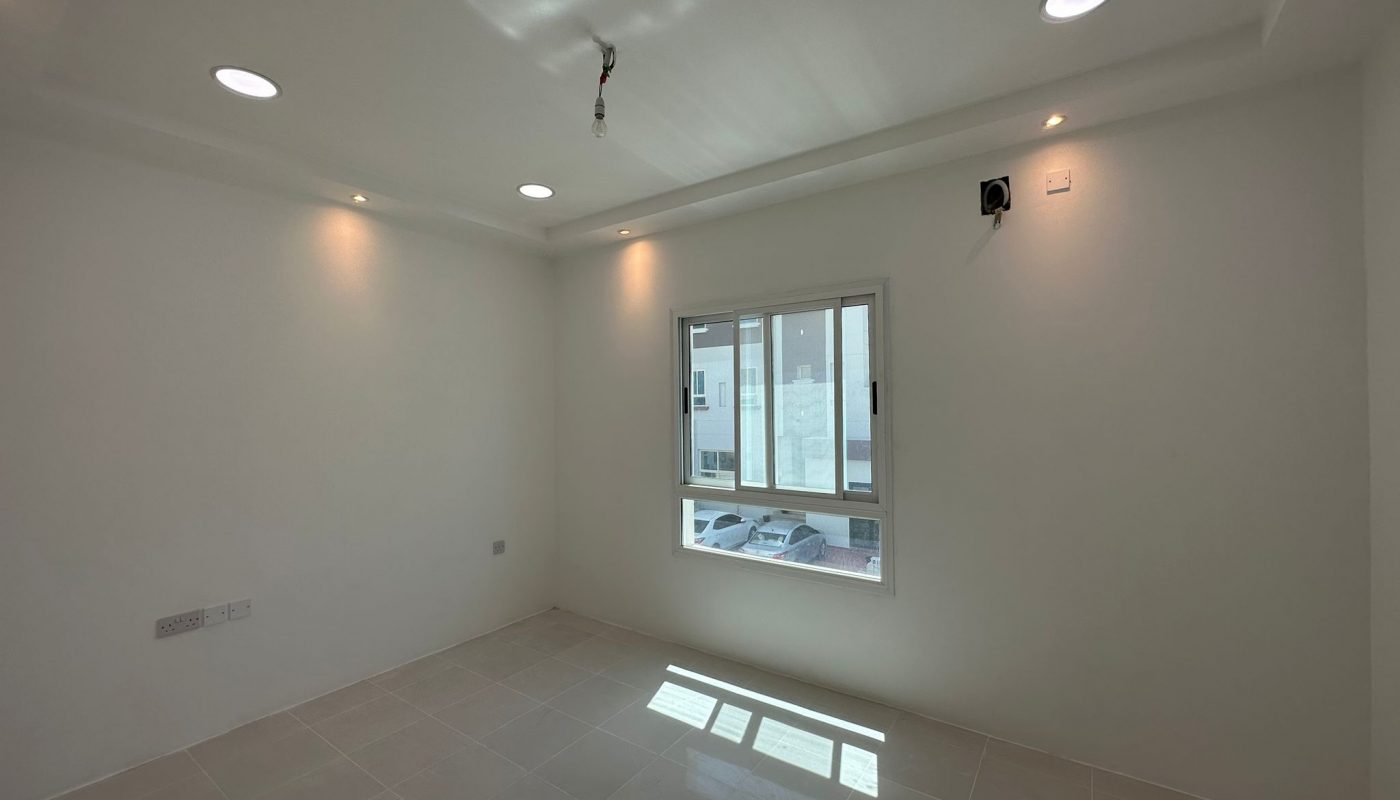 A commercial office for rent in Sanabis, featuring white tile floors and a window.