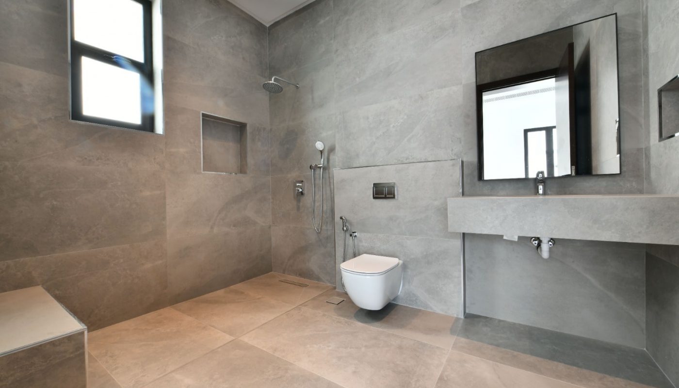 A modern bathroom with grey walls and a toilet in a Modern Villa.