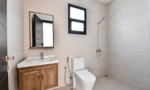 A luxury bathroom with a toilet, sink, and window in a 3BR Villa for sale in Damistan.