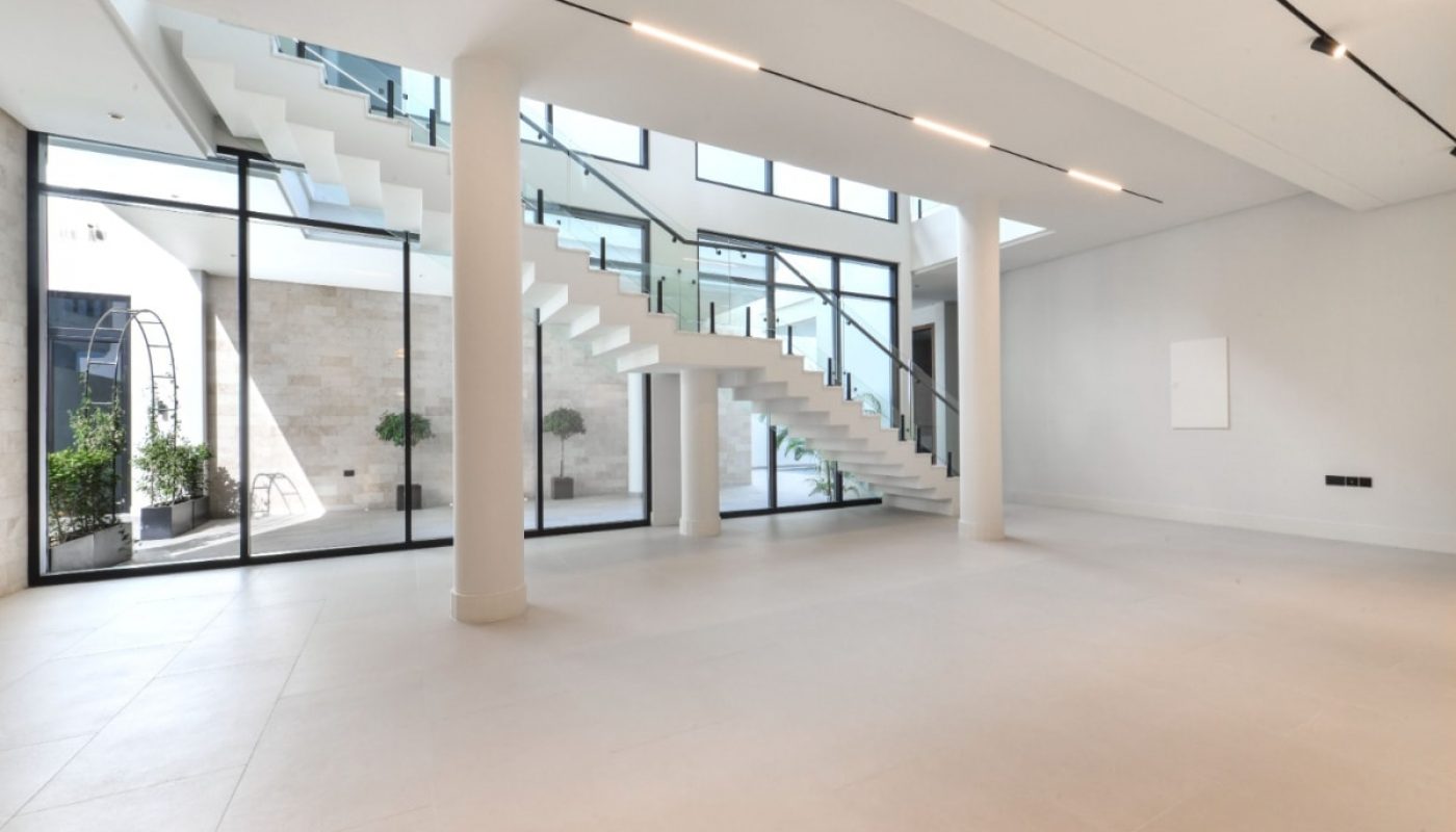 A luxurious villa with glass walls and a staircase.