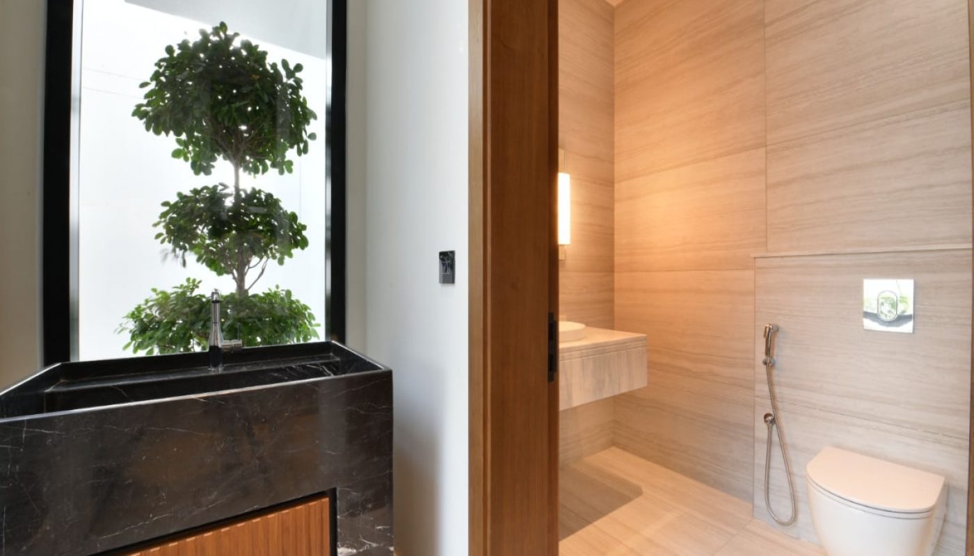 A luxurious villa with a modern bathroom featuring a toilet and a plant is available for sale.