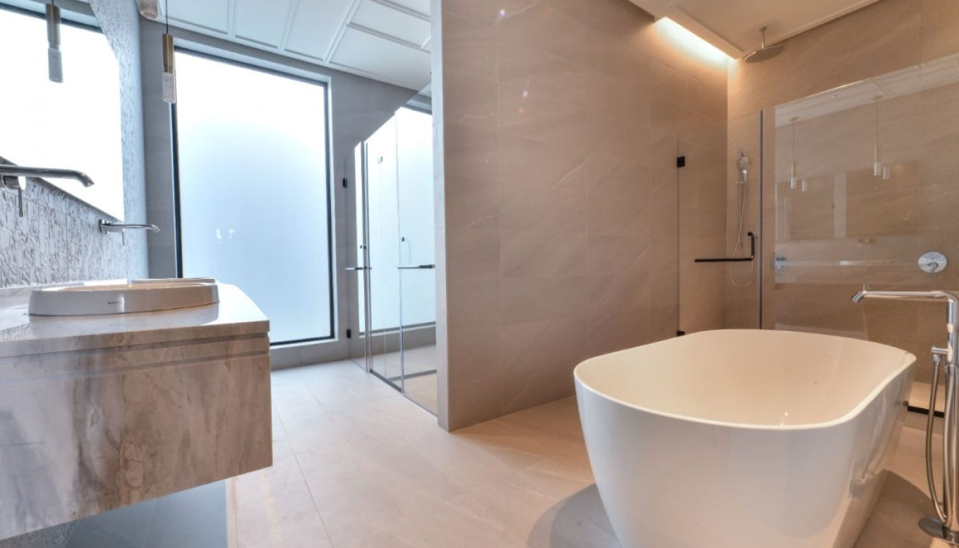 A luxurious villa for sale in Saar featuring a modern bathroom with a large tub and glass shower.