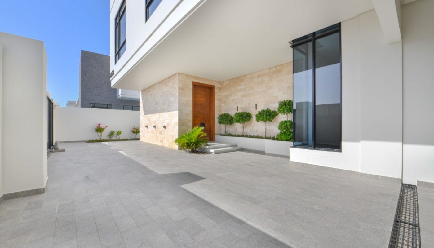 A luxurious villa for sale in Saar with a modern house featuring a beautiful courtyard adorned with plants.