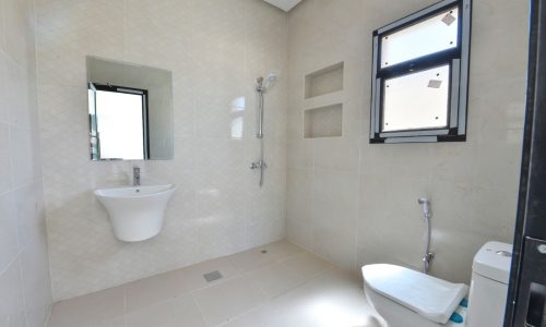 A 4-Bedroom Villa for Sale with a Damistan-themed bathroom featuring a toilet, sink, and window.