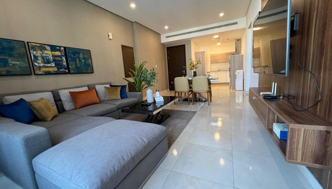 A living room with a couch, coffee table and tv.