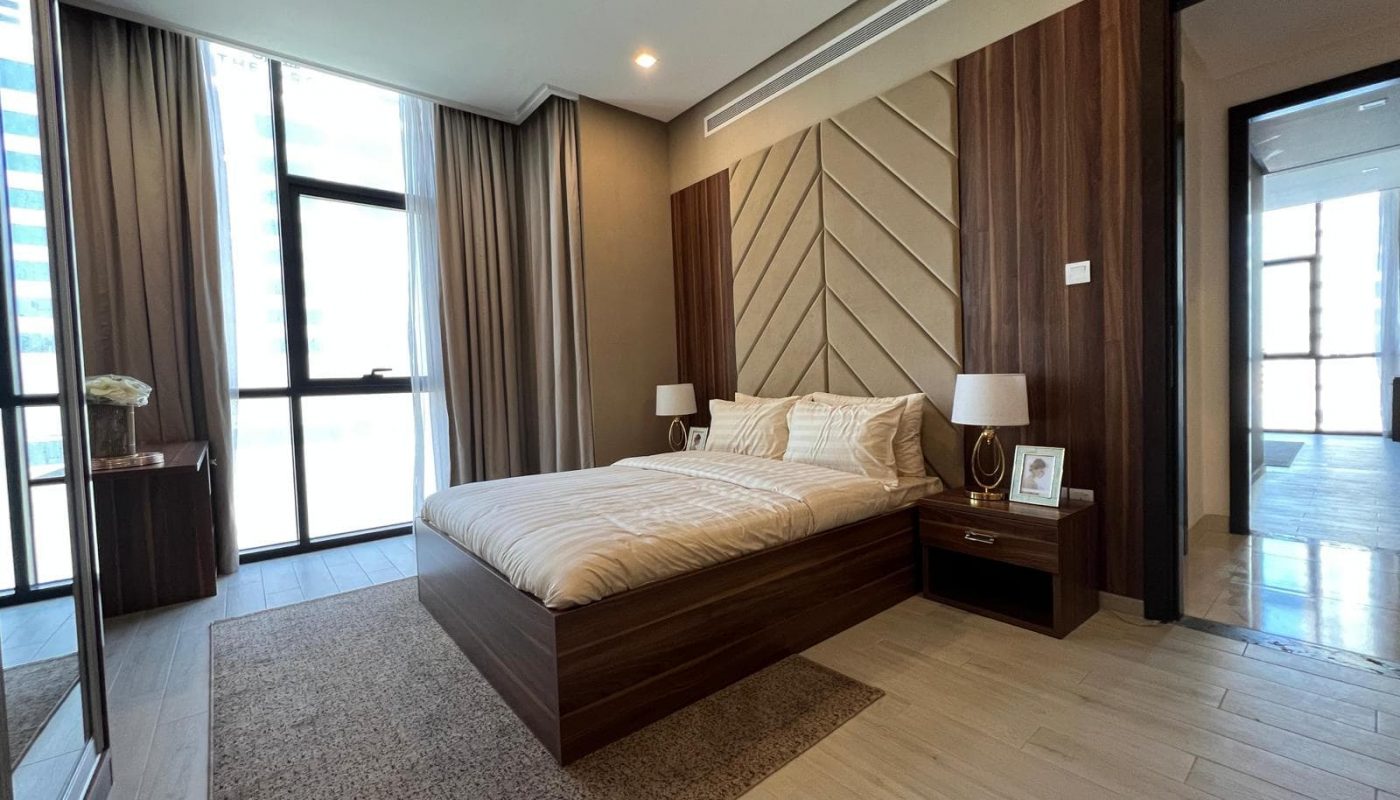 A bedroom with a bed and a sliding glass door.