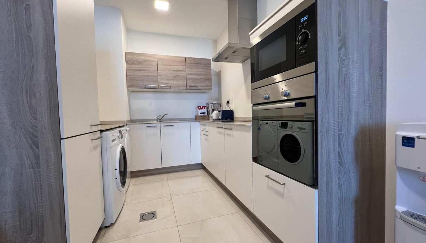 A small kitchen with a washer and dryer.