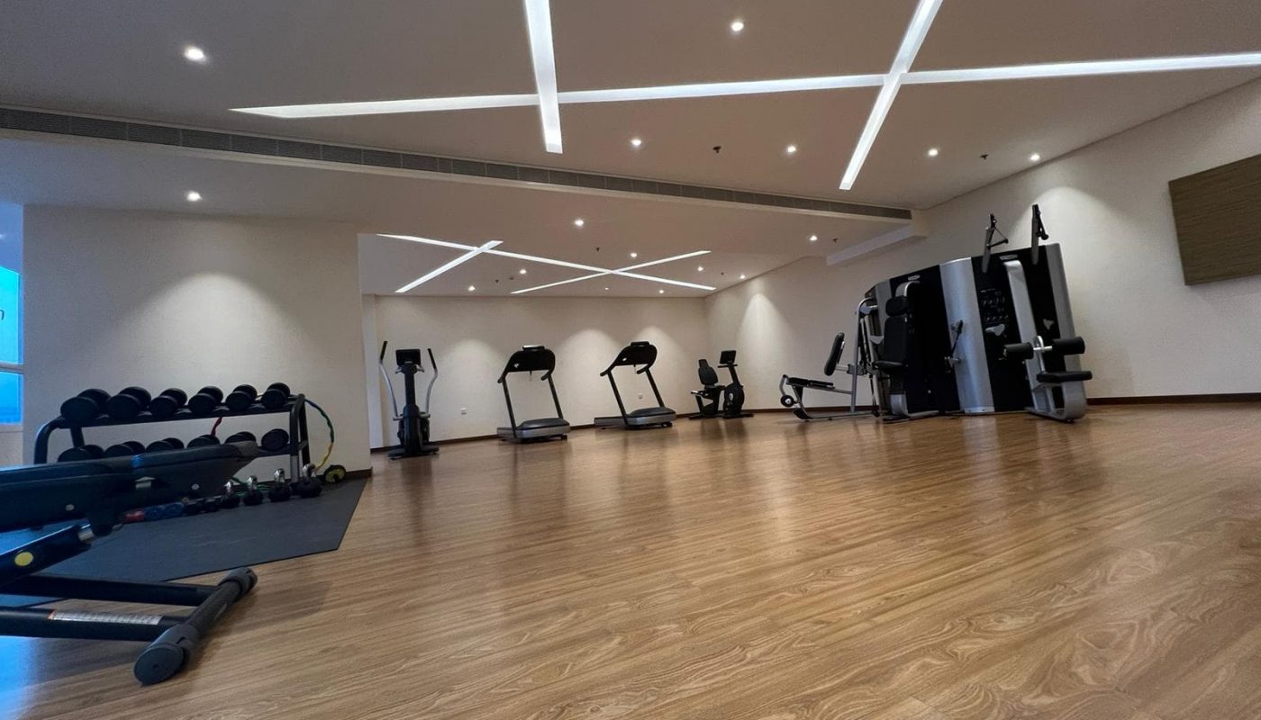 A spacious gym room equipped with treadmills and weights.