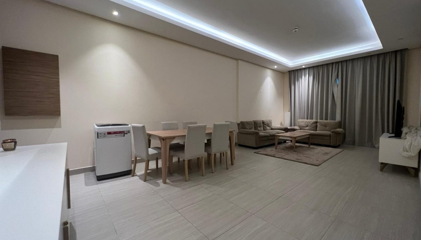 A spacious and fully furnished living room and dining room in a modern apartment.