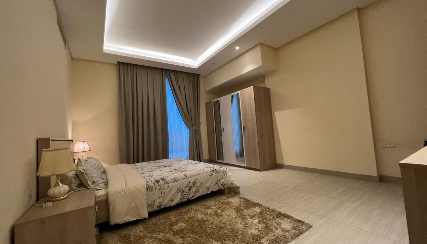 A spacious bedroom in a fully furnished apartment.
