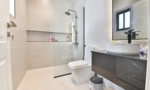 A modern bathroom with a glass shower stall located in a Rent Janabiyah Modern Villa.