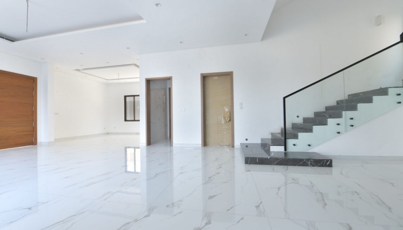 A luxurious white house with wooden stairs and marble floors, located in Janabiya Area.