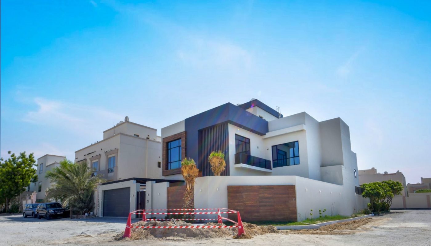 A luxurious villa in the desert with a car parked in front of it.