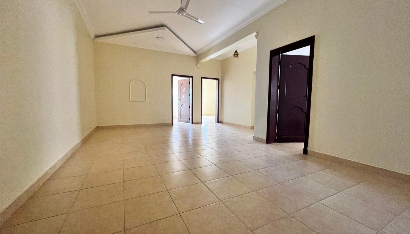 A spacious apartment with tiled floors and a ceiling fan for rent.