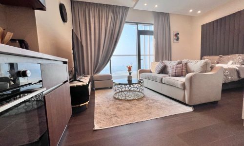 A modern studio apartment available for rent in Juffair, featuring a living room and kitchen area.