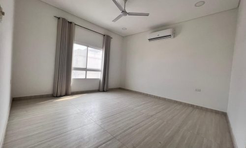 A spacious apartment in Juffair with wooden floors and a ceiling fan.