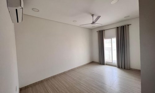 A spacious room with wooden floors and a ceiling fan in Juffair.