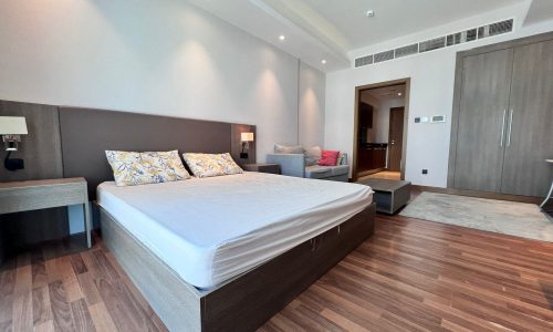 A luxurious residential bedroom with wooden floors and a bed.