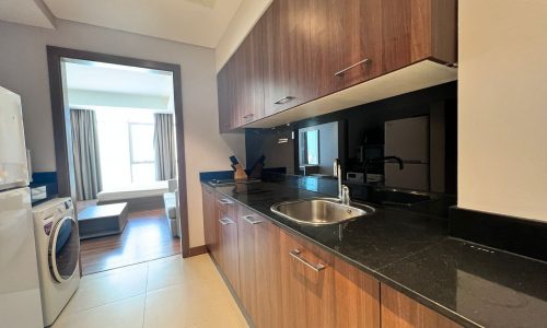 A luxurious residential apartment in the Sanaibis towers featuring a kitchen with a washer and dryer.