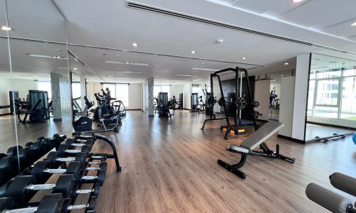 A Sanaibis gym with weights and mirrors in a large room, perfect for those seeking a luxurious residential tower experience or their dream apartment.