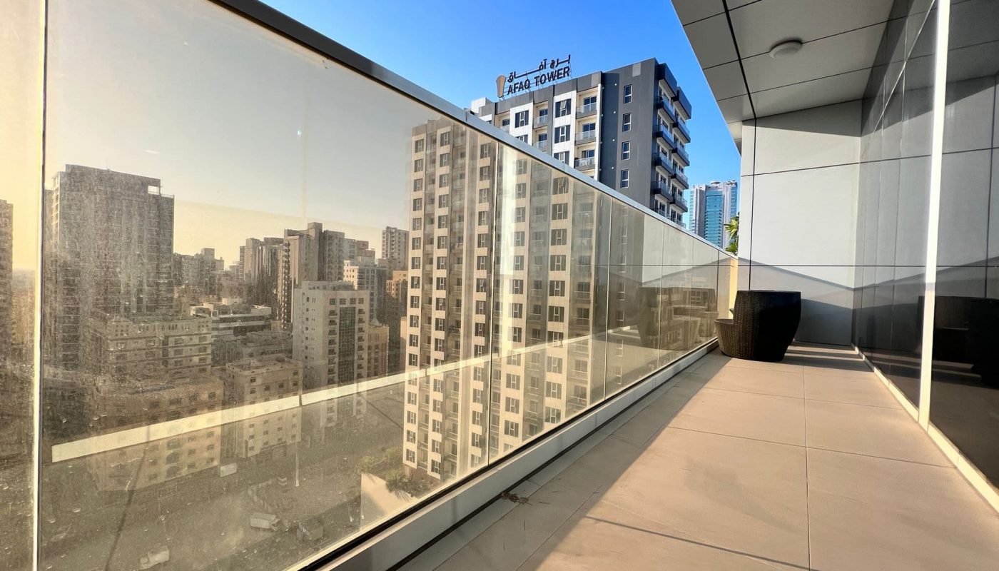 A luxury living experience with a balcony featuring glass railing, offering breathtaking views of the city.