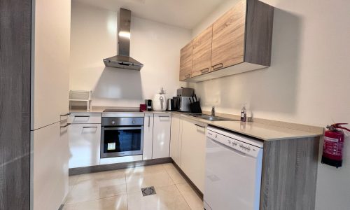 A small kitchen with white cabinets and a stove in a luxury living space in Juffair, featuring 1 bedroom.