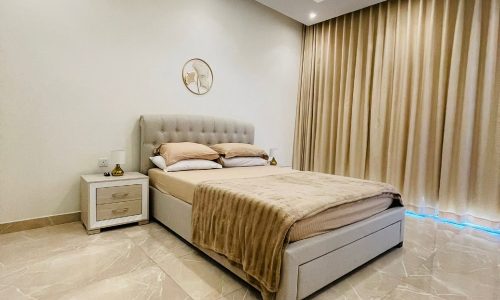 A bedroom with beige walls and a white bed, described as "Auto Draft.