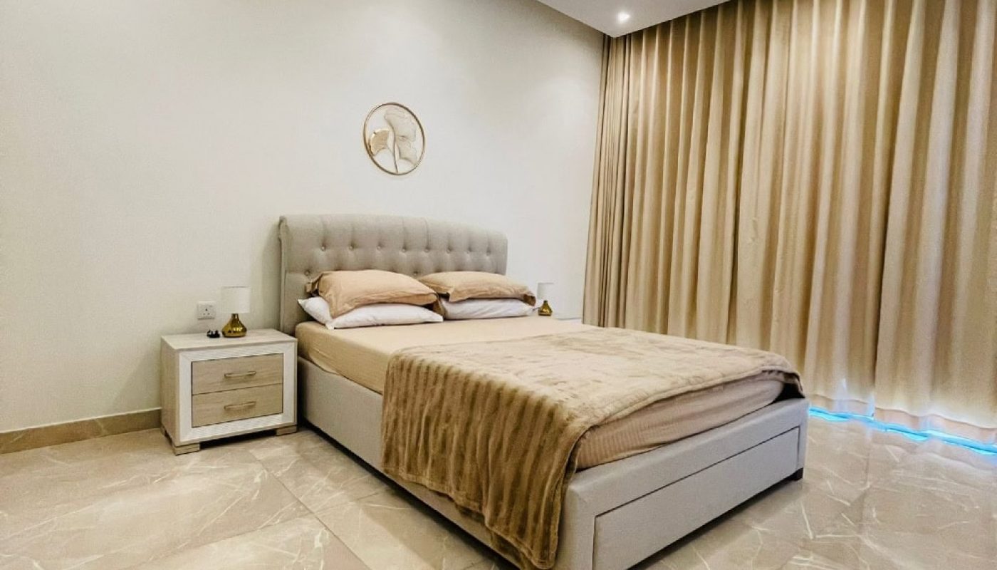A bedroom with beige walls and a white bed, described as "Auto Draft.