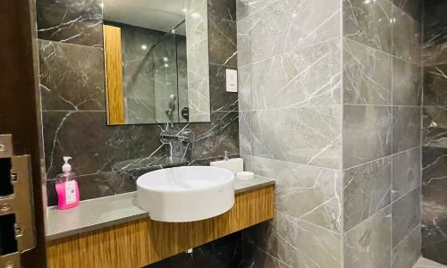 A bathroom with marble walls and an Auto Draft sink.