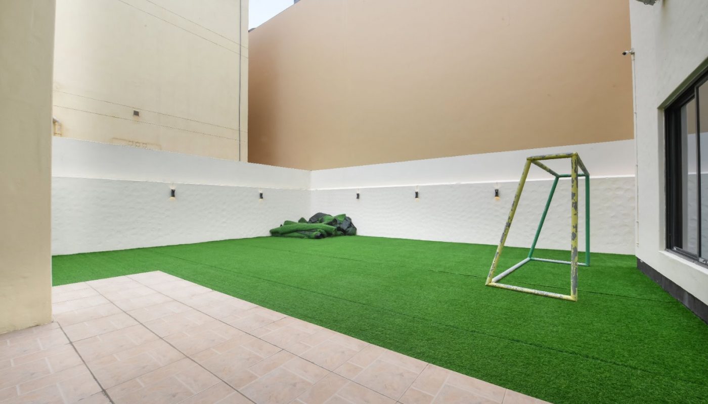 نظرًا لعدم توفر أي كلمات رئيسية محددة، سأضيف كلمة رئيسية ذات صلة لتحسين الوصف:

فناء خلفي صغير ساحر يتميز بالعشب الاصطناعي ومجموعة أرجوحة مبهجة.