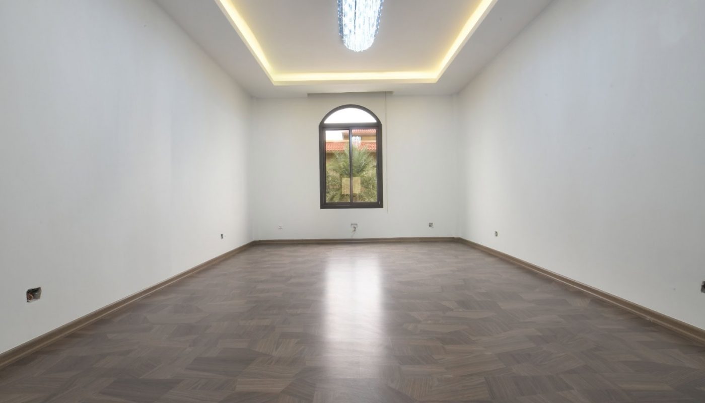 غرفة فارغة ذات أرضيات خشبية ونافذة كبيرة، وتتميز بنظام السحب التلقائي.