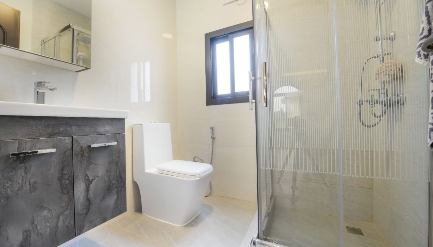 حمام مزود بكابينة دش زجاجية ومرحاض وميزة Auto Draft.