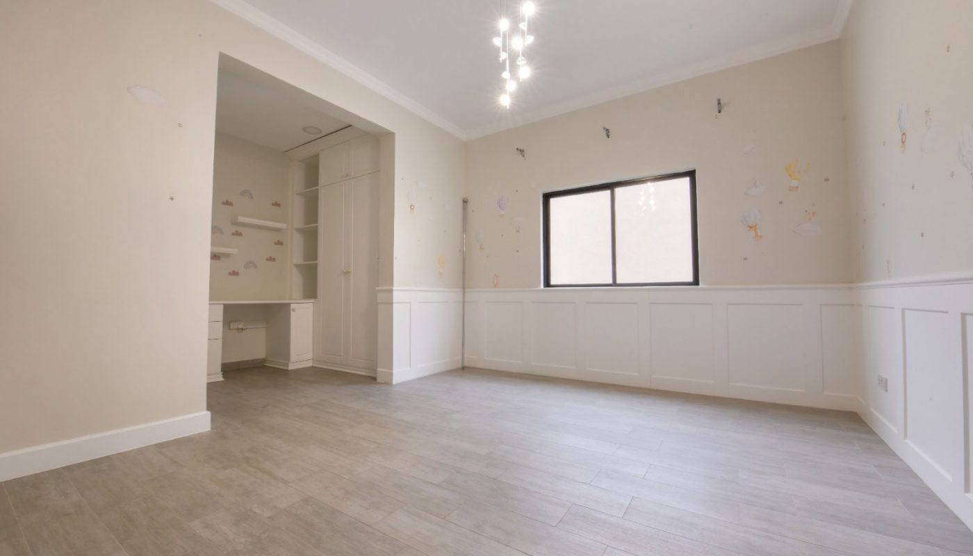 غرفة فارغة ذات جدران بيضاء وأرضيات خشبية تنتظر المسودة التلقائية.