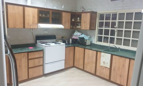 A kitchen with wood cabinets and a stove.