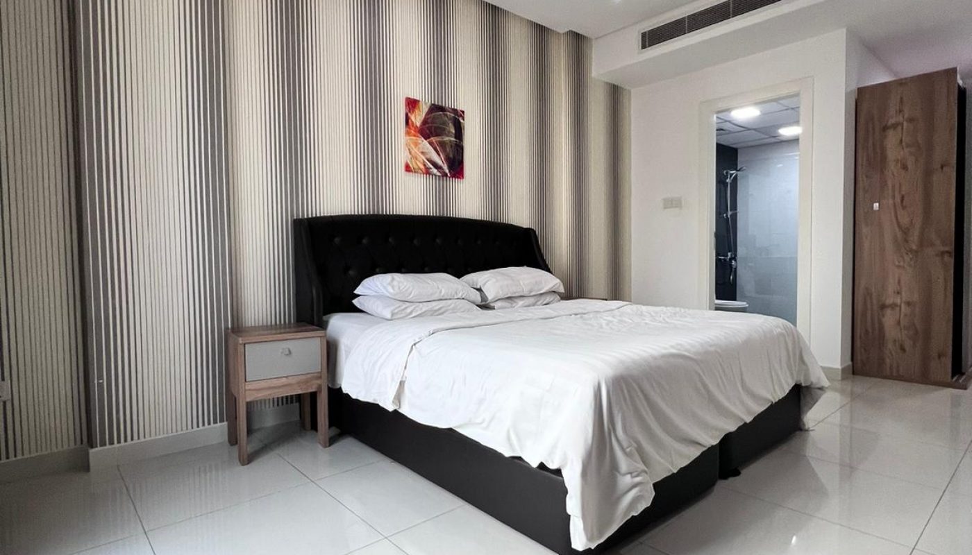 A modern bedroom with a white bed and tiled floor, perfect for a luxury apartment.